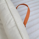 Large Dog Bed Leather Soft Plush Donut Snuggly Warm Cozy Pet Mat for S with an orange handle for easy transport.
