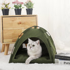 Cozy cat resting in a Pet Tent Bed for Cats Cozy Winter Cat House placed beside flowers and a wooden cabinet.